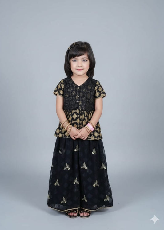 Young girl wearing a black and gold traditional outfit on a gray background